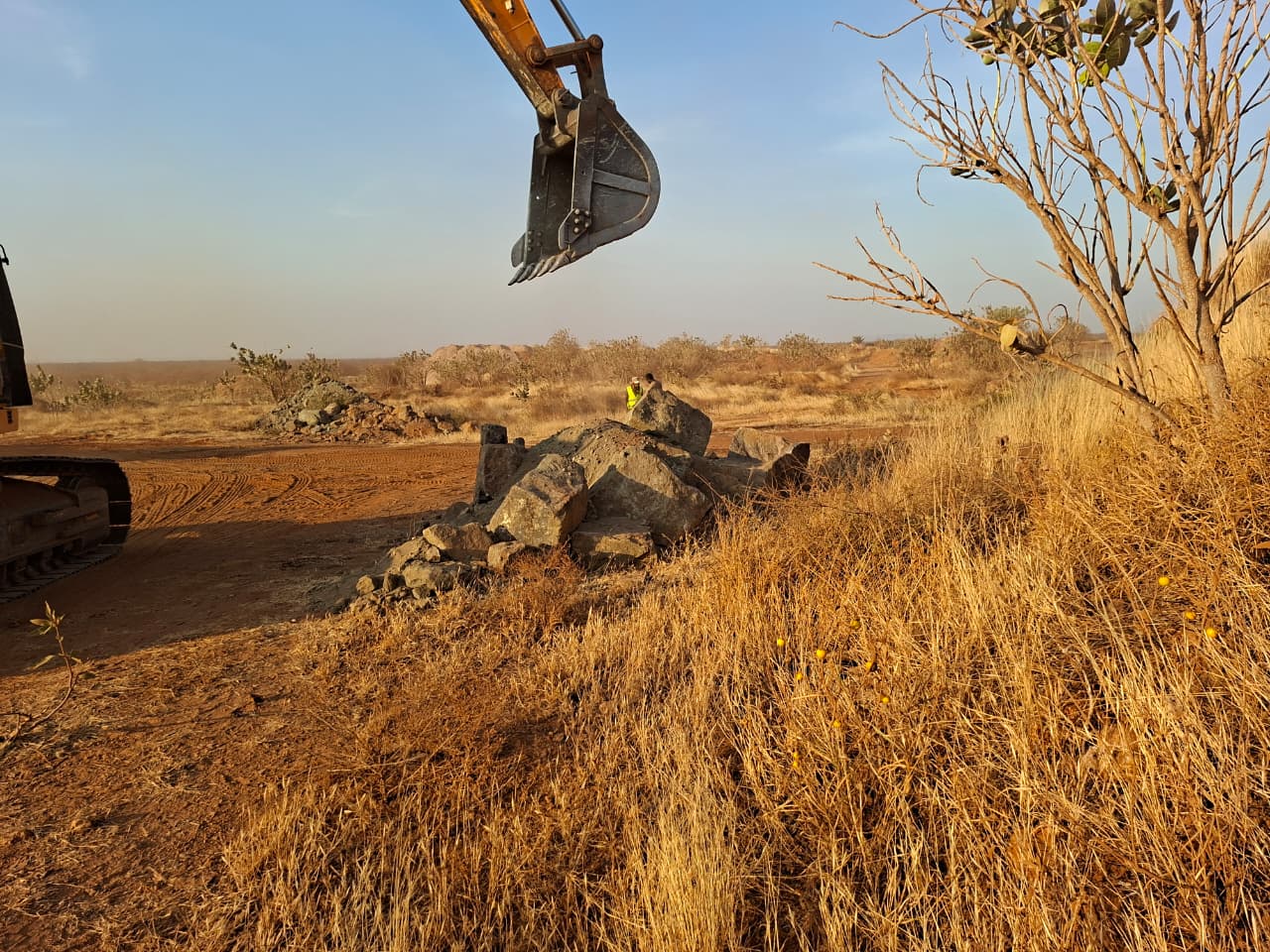 Excavator arm above run-of-mine ore